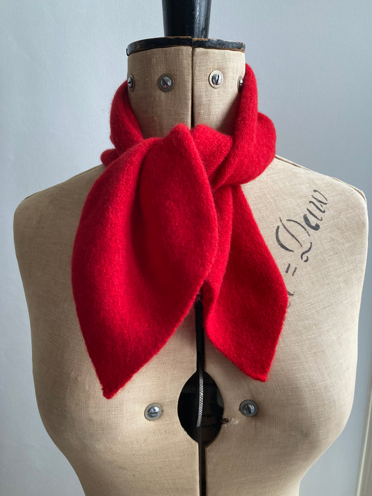 Bright red knitted neck tie scarf tied on a mannequin.