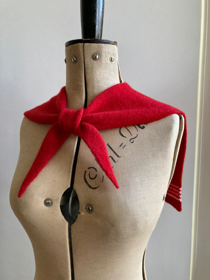 Knitted red sailor scarf with pale pink stripes styled on a mannequin.