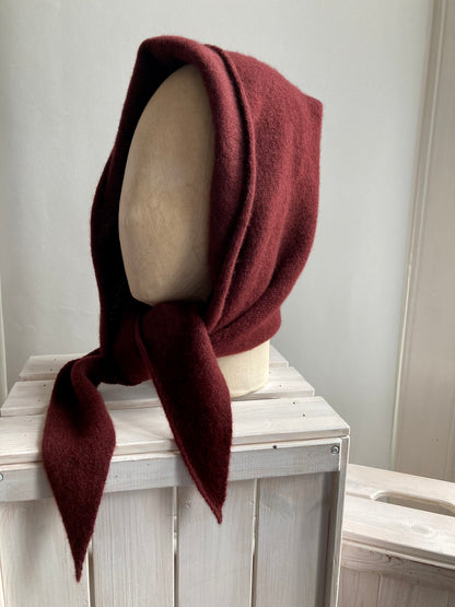 Red brown knitted hooded scarf styled on a mannequin head.