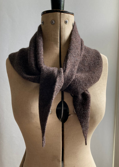 A dark brown knitted neckerchief scarf wrapped around a mannequin. 