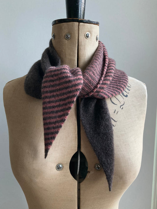 A knitted neckerchief scarf in a half dusty rose and brown stripe and half plain brown design. Styled on a mannequin.