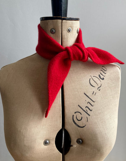 A bright red thin bandana tied around the neck of a mannequin.