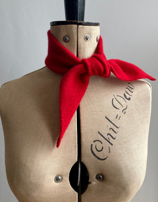 A bright red thin bandana tied around the neck of a mannequin.