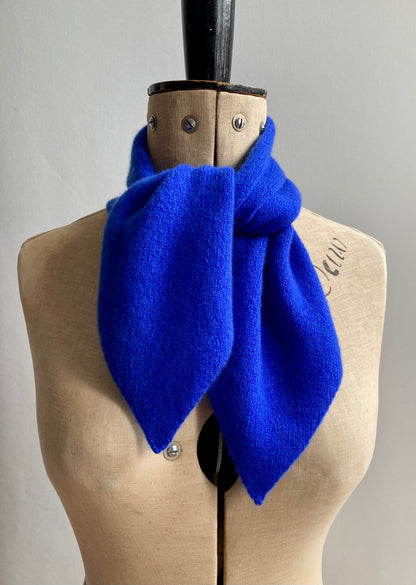 A bright cobalt blue scarf tied on a mannequin.