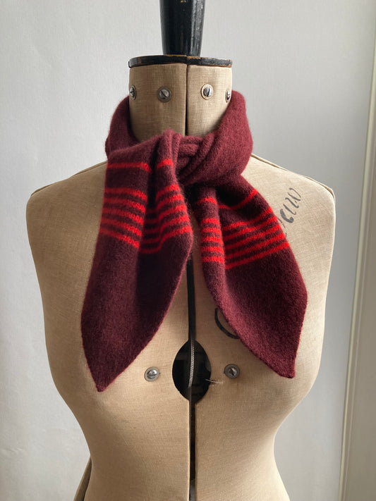 A burgundy wool neck tie scarf with red stripes, styled on a mannequin.