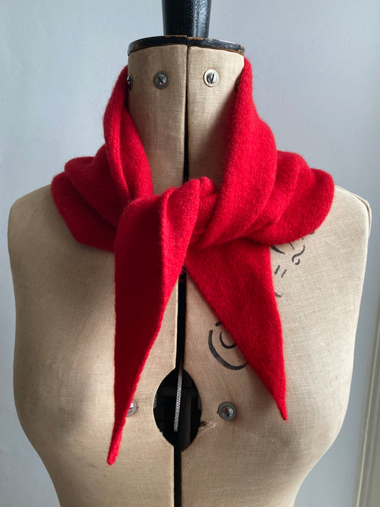 A bright red wool neckerchief scarf tied on a  mannequin.